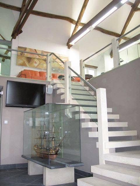 Stone stairs with glass rails rising to our laboratory under the oak beams of the barn